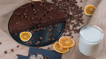 slices of chocolate brownie cake with cap milk and coffee beanas on wooden tableの写真素材