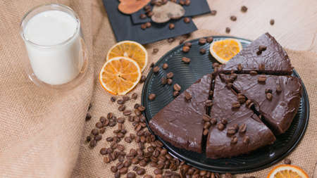 slices of chocolate brownie cake with cap milk and coffee beanas on wooden tableの写真素材