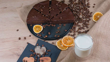 slices of chocolate brownie cake with cap milk and coffee beanas on wooden tableの写真素材