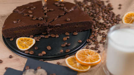 slices of chocolate brownie cake with cap milk and coffee beanas on wooden tableの写真素材