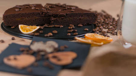 slices of chocolate brownie cake with cap milk and coffee beanas on wooden tableの写真素材