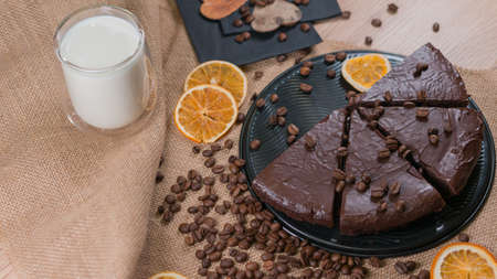 slices of chocolate brownie cake with cap milk and coffee beanas on wooden tableの写真素材