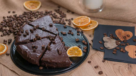 slices of chocolate brownie cake with cap milk and coffee beanas on wooden tableの写真素材