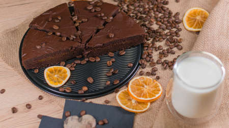 slices of chocolate brownie cake with cap milk and coffee beanas on wooden tableの写真素材
