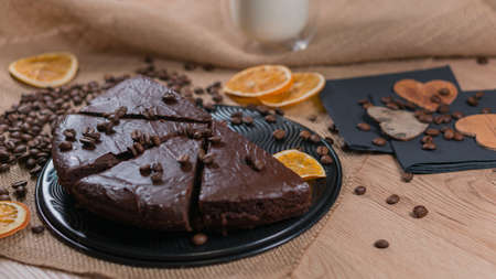 slices of chocolate brownie cake with cap milk and coffee beanas on wooden tableの写真素材