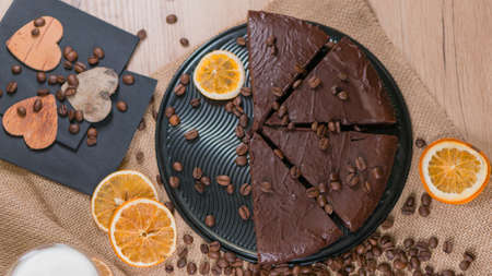 slices of chocolate brownie cake with cap milk and coffee beanas on wooden tableの写真素材