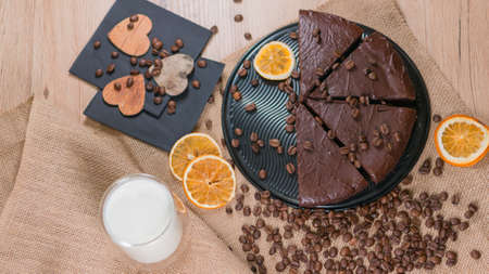 slices of chocolate brownie cake with cap milk and coffee beanas on wooden tableの写真素材