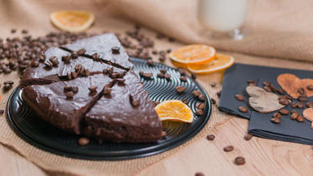 slices of chocolate brownie cake with cap milk and coffee beanas on wooden tableの写真素材