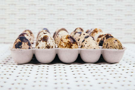 Quail eggs in paper box on white rattan background, side view.の写真素材