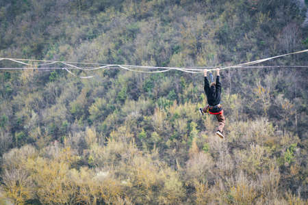Man falling from high lina into the space in mountains. High line contest.の写真素材