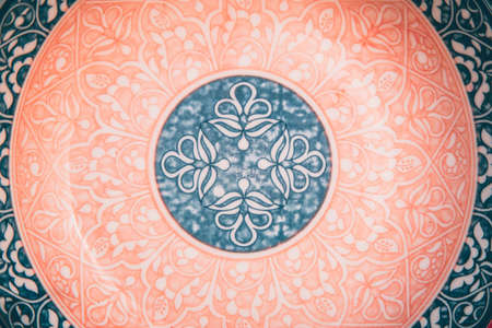 Beautiful authentic ornate floral pattern of pink, blue and white color plate. Round focused. Flat...