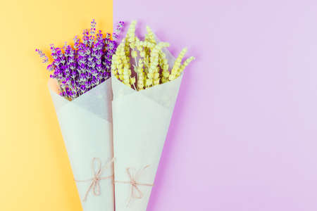 Flat lay style composition of lemongrass and lavender herbs  flower wrapped into craft paper on colorful  background.の写真素材