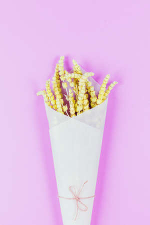 Flat lay style composition of lemongrass herbs  flower wrapped into craft paper on colorful  background.の写真素材