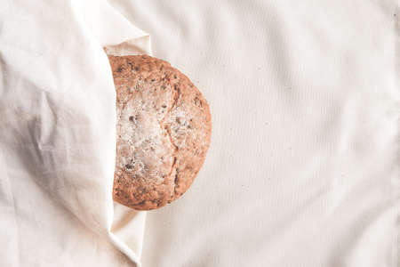 Fresh homemade backed brown bread with seeds and cereals on linen background.の写真素材