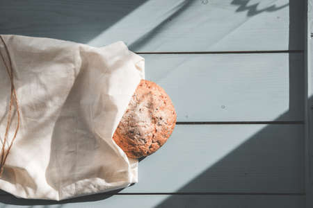 Fresh homemade backed brown bread with seeds and cereals on wooden board and linen background.