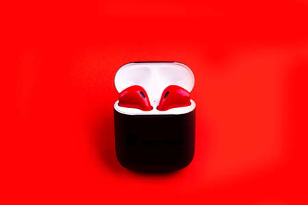 Elegant wireless  red earphones in black box on red nackground.の写真素材