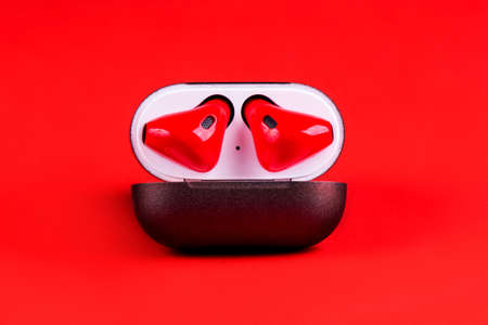Elegant wireless  red earphones in black box on red nackground.の写真素材