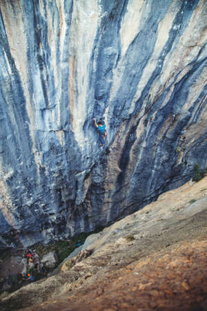 Athletic man climbs very high tufa rock with rope in Turkey. Sport climbing, lead.の写真素材