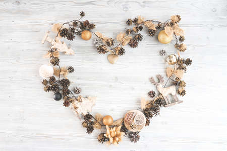 Heart shaped new year composition made of christmas balls. trees, deer, and many different knick knacks on a wooden backgroundの写真素材