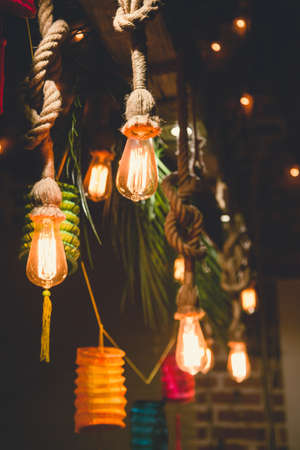 Colorful paper lanterns and bulbs hanging as a party decor. Night party.の写真素材
