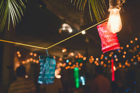 Colorful paper lanterns and bulbs hanging as a party decor. Night party.の写真素材