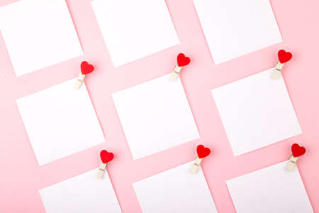 White blank square shape stickers with heart pins on cute pink background, Valentine's day card design. Flat lay style.の写真素材