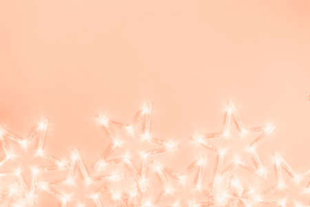 Star shaped garland lights on soft pink background. Festive project backdrop.