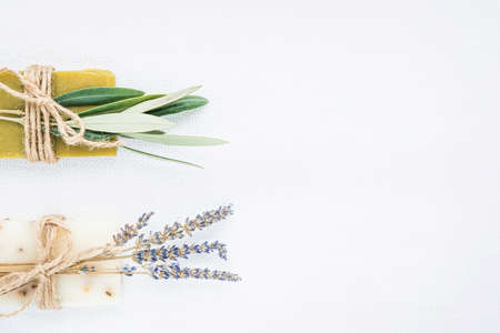 Two pieces of natural organic lavender and olive soap packed with dried lavender and olive branch on light linen background. Organic spa set.の写真素材