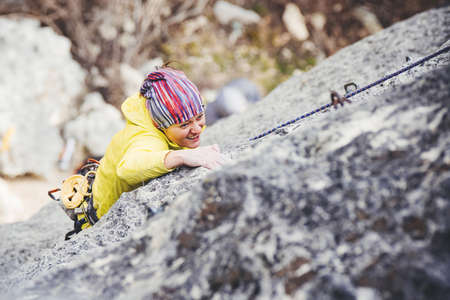 Athletic woman in colorful sportswear climbs a rock with rope. Sport climbing, lead. Top view. Crimea.の写真素材