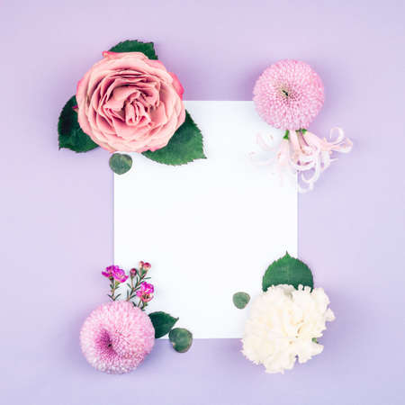 Flower card made of roses, chrisantemum, carnation and baby eucalyptus leaves with white blank paper in the cennter. For holiday project.の写真素材