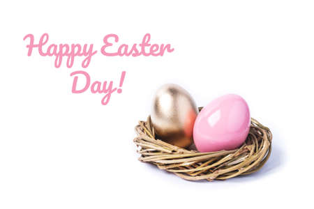 Pink and golden colored easter eggs in rattan nest on isolated white. Easter concept.の写真素材
