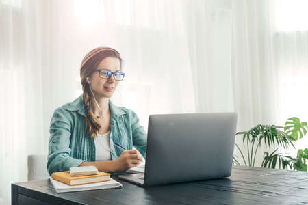 Young woman doing some on-line classes staying at home. Self isolation concept.の写真素材