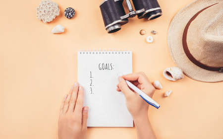 Travel accessories made of note pad, straw hat, binoculars, sun glasses and sea shells. Travel goals or preparation concept. Flat lay style.の写真素材