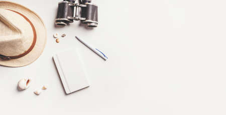 Travel accessories made of note pad, straw hat, binoculars, sun glasses and sea shells. Travel goals or preparation concept. Flat lay style.の写真素材