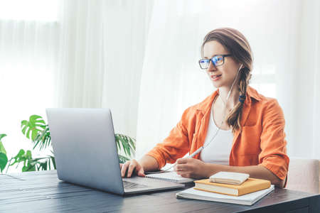 Young woman doing some on-line classes staying at home. Self isolation concept.の写真素材