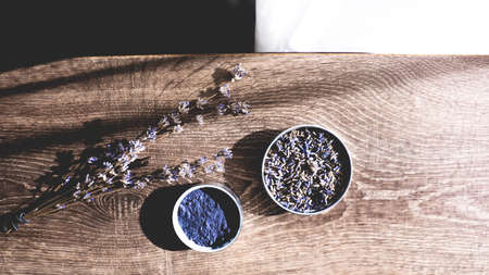 Cosmetic ingredients set made of organic lavender branches, lavender powder on wooden background.の写真素材