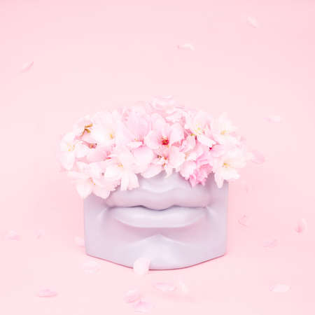 Bouquet of pink japanese sakura flowers in modern lips shaped vase. Modern art beauty concept.の写真素材