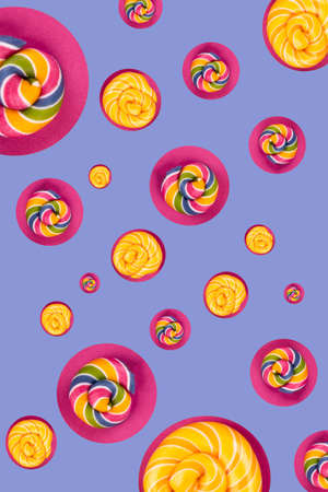 Many colorful lollipop candies arranged random on pink background. Flat lay concept for party or holiday.の写真素材