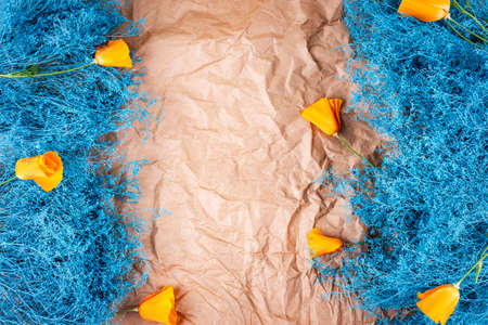 Abstract sea wave colored decorating dry plant bush and orange flowers on crumpled craft paper card. Abstract background.の写真素材
