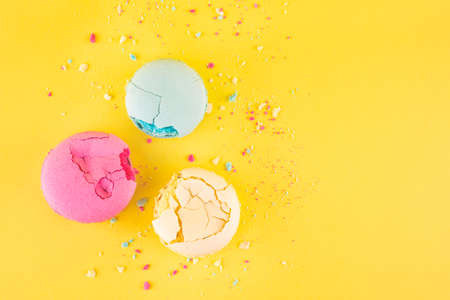 Three colorful macarons dessert lying on the  crumbsの写真素材