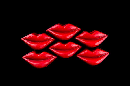 Colorful red lips shaped chocolate candies on isolated black.の写真素材