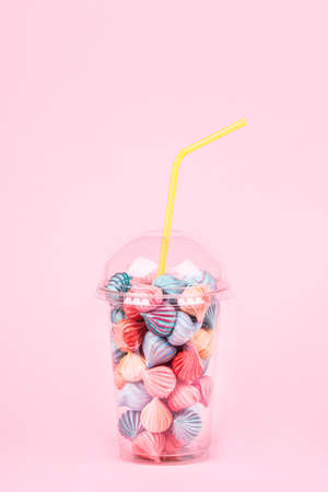 Soft pink and blue color mini marshmallows dessert in plastic glass with cocktail straw