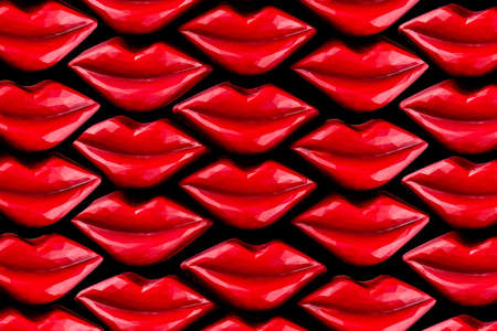 Colorful red lips shaped chocolate candies on isolated black. Holiday gift background, top view.の写真素材