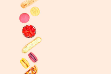 Plenty colorful desserts such as strawberry tart, nut and caramel tart, macarons and eclairs, flat...