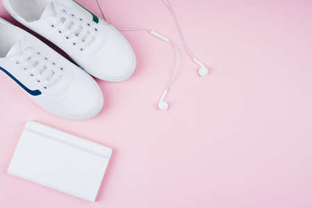 White classic style sneakers, white earphones and white copy book, flat lay style.. Sport style concept.の写真素材