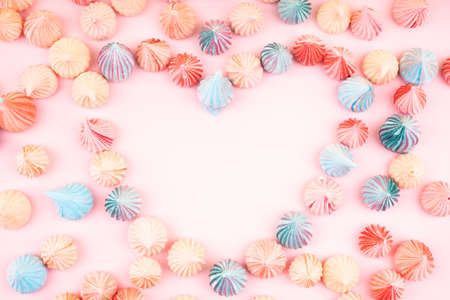 Soft pink, blue and orange color of mini heart shaped marshmallows dessert top view, flat lay style. Concept for holiday party card.の写真素材