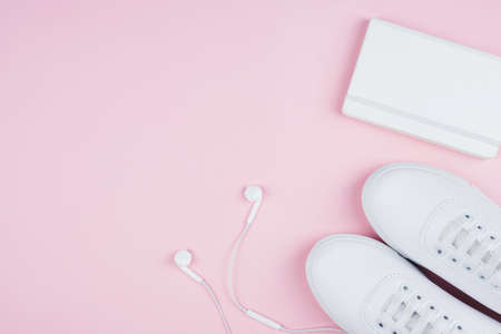 White classic style sneakers, white earphones and white copy book, flat lay style.. Sport style concept.の写真素材