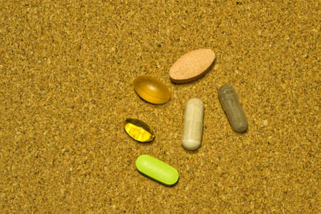 An assortment of dietary supplements on cork background