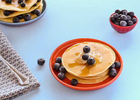 Gluten free blueberry, pancakes on blue table with serving of blueberries in the backgroundの写真素材