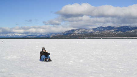 South Lake Tahoe, California, USA, 10 January 2016. Unidentified young man and crowd in the background enjoy the frozen waters of lake tahoe in the winter.のeditorial素材